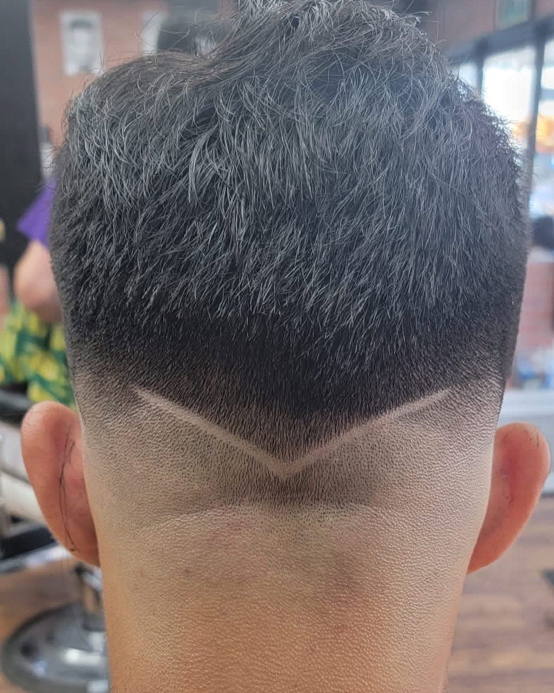 The back of a fade with a V-shaped design cut into the neckline
